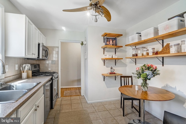 kitchen featuring a sink, open shelves, backsplash, white cabinetry, and stainless steel appliances