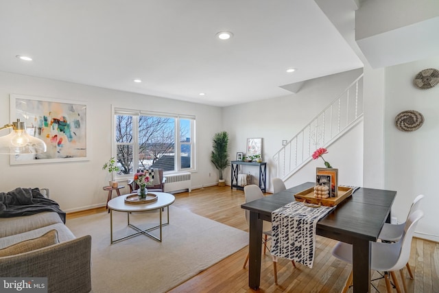 living area featuring recessed lighting, stairway, radiator, and light wood-style flooring