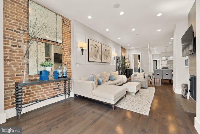 living area featuring baseboards, hardwood / wood-style floors, and recessed lighting