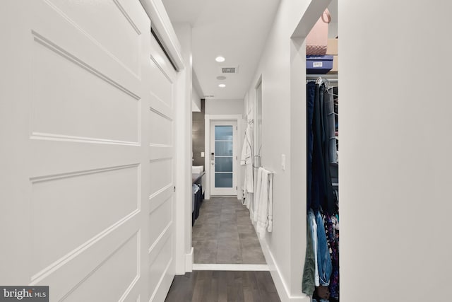 corridor with baseboards, wood finished floors, visible vents, and recessed lighting