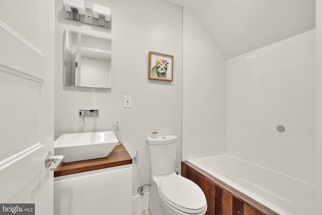 full bathroom with vaulted ceiling, vanity, toilet, and a bath