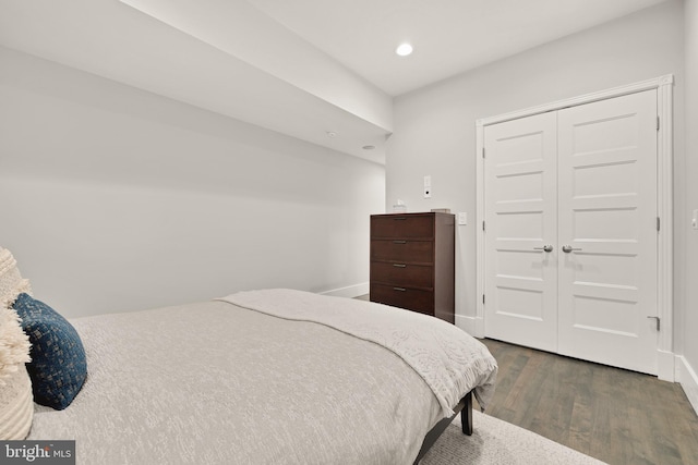 bedroom with a closet, baseboards, wood finished floors, and recessed lighting