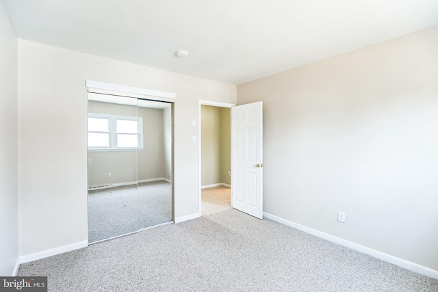 unfurnished bedroom featuring baseboards, a closet, and carpet flooring