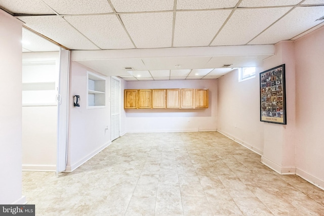 interior space with a drop ceiling and baseboards