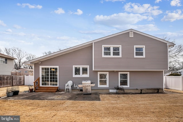 back of property featuring entry steps, a yard, a patio, and a fenced backyard