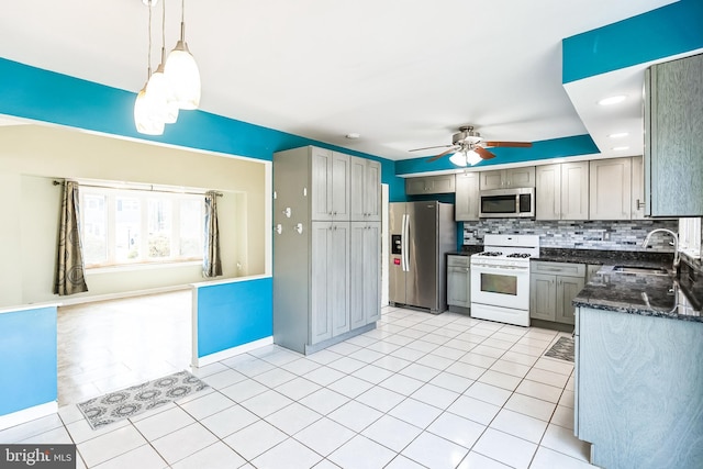 kitchen featuring tasteful backsplash, a ceiling fan, appliances with stainless steel finishes, a sink, and light tile patterned flooring