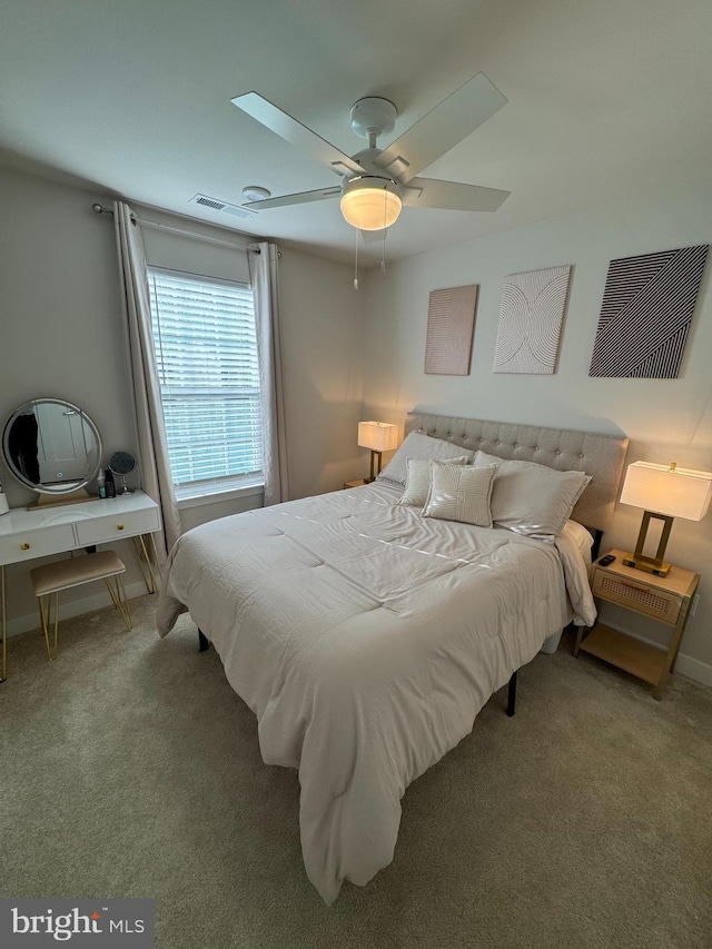 carpeted bedroom with a ceiling fan, visible vents, and baseboards