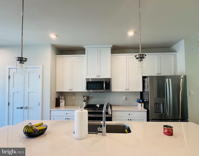 kitchen with stainless steel appliances, a sink, hanging light fixtures, light countertops, and tasteful backsplash