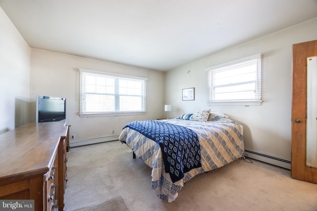 bedroom with a baseboard heating unit and light carpet