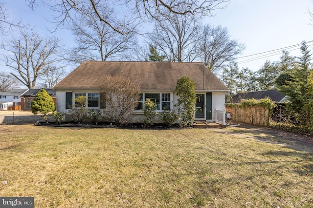 view of front facade featuring a front yard, fence, and brick siding