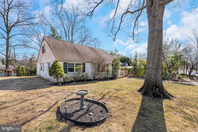 view of side of property with a lawn and roof with shingles