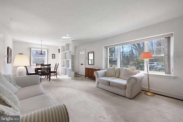 living room featuring an inviting chandelier and light colored carpet