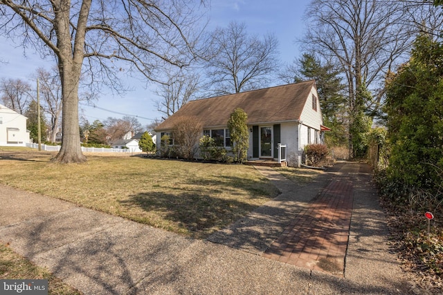 view of front of property with brick siding, a front yard, and fence