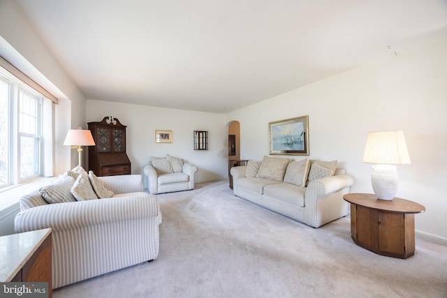 carpeted living room with arched walkways