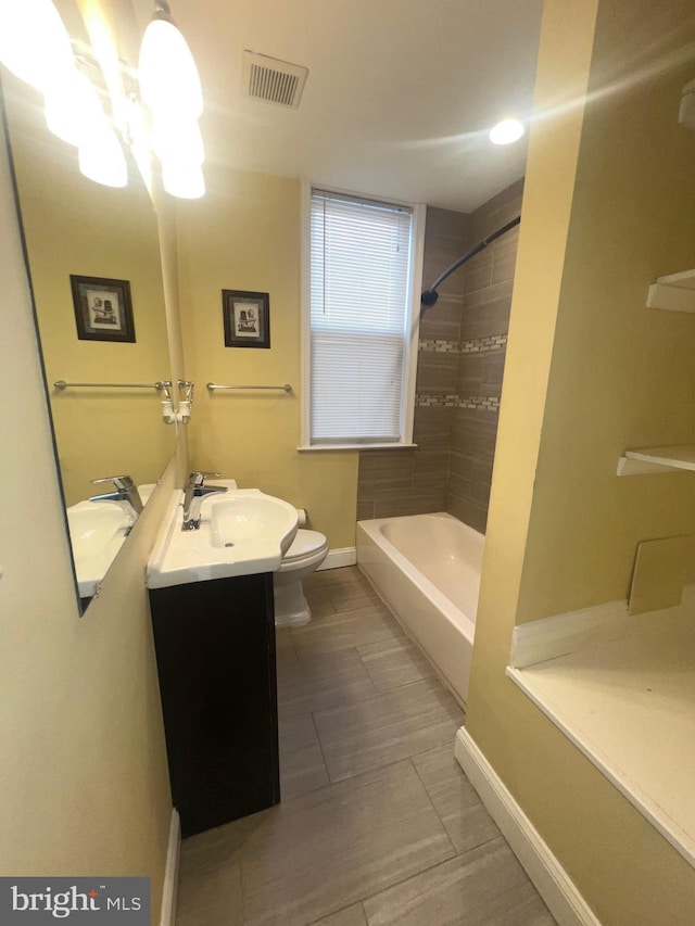 full bathroom with toilet, vanity, visible vents, baseboards, and shower / bathing tub combination