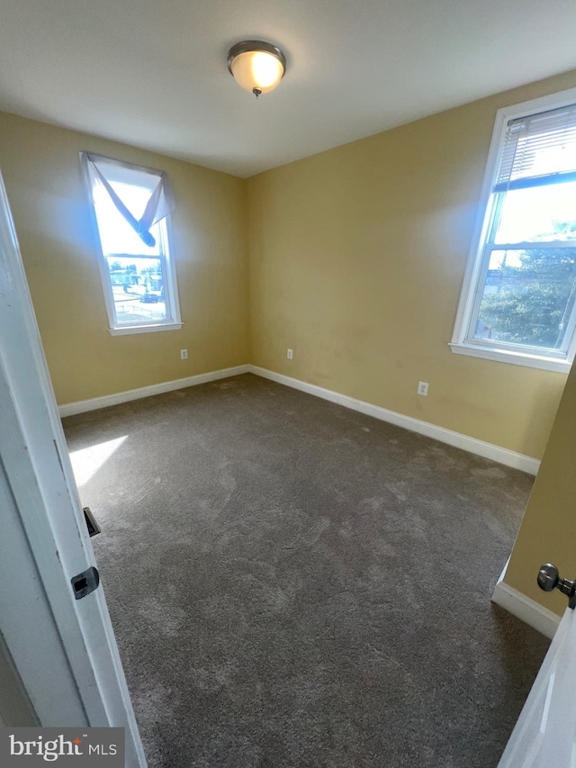 unfurnished room featuring carpet, a healthy amount of sunlight, and baseboards