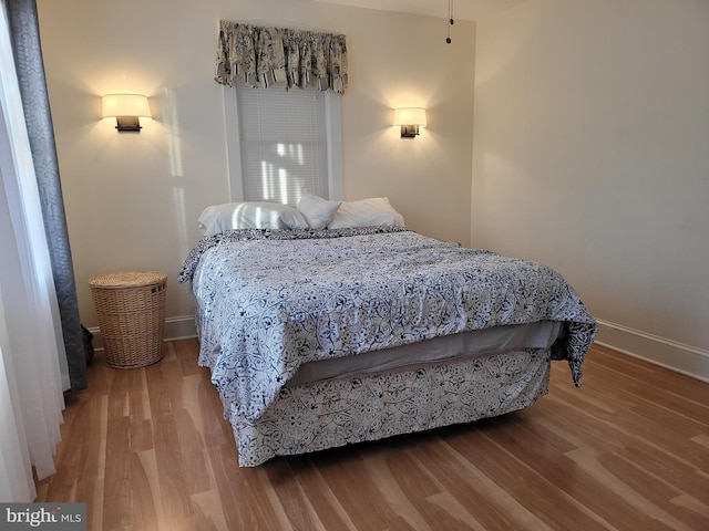 bedroom featuring baseboards and wood finished floors