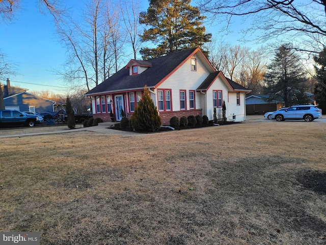 view of front facade with a front yard and brick siding