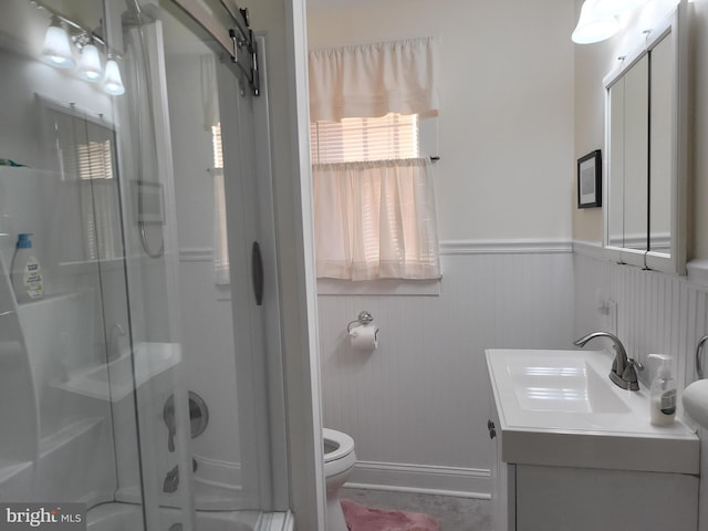 full bath featuring wainscoting, toilet, a shower stall, and vanity