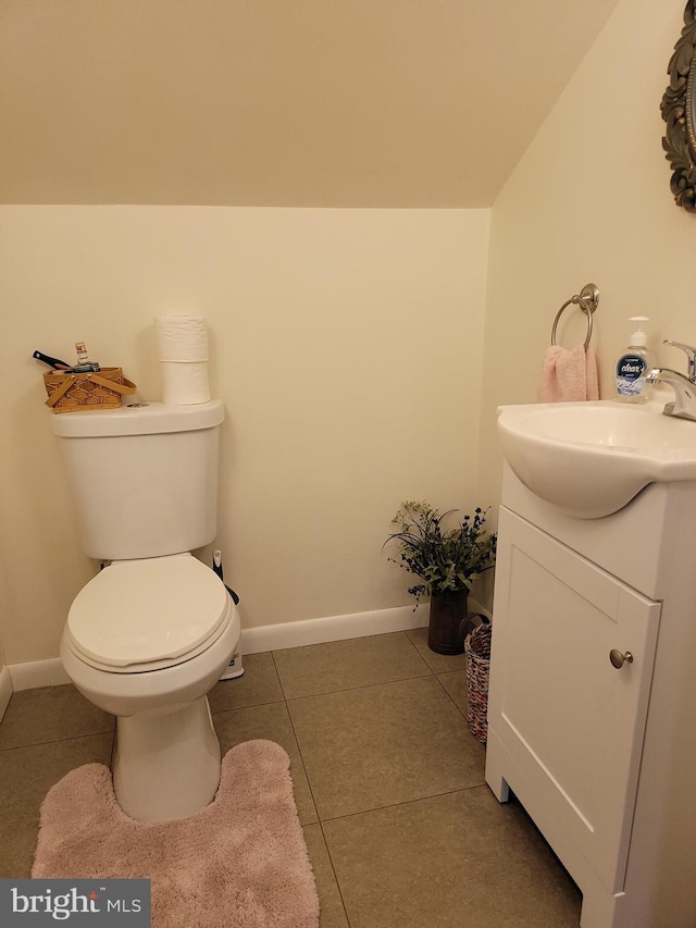 bathroom with baseboards, toilet, vanity, and tile patterned floors