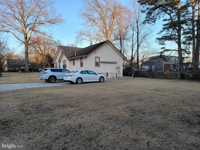 view of side of property featuring a chimney and a lawn