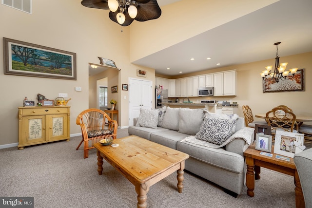 living room featuring recessed lighting, ceiling fan with notable chandelier, light colored carpet, visible vents, and baseboards