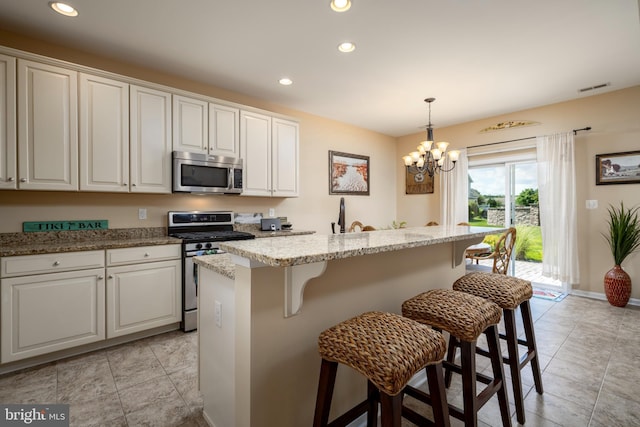 kitchen with appliances with stainless steel finishes, a breakfast bar area, visible vents, and recessed lighting