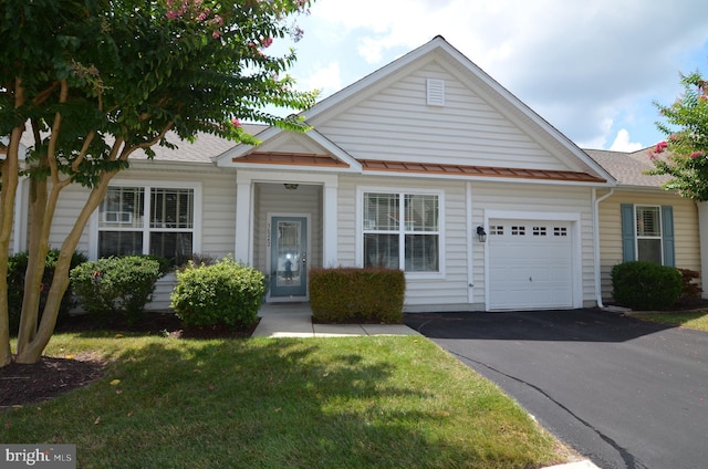 view of front of house featuring a front lawn, roof with shingles, driveway, and an attached garage