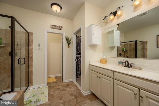 full bath featuring visible vents, vanity, baseboards, a spacious closet, and a stall shower