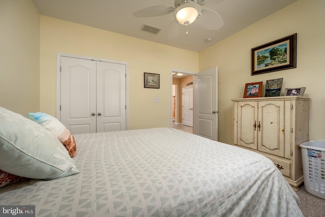 carpeted bedroom with a closet, visible vents, and ceiling fan