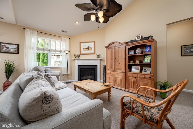 living area featuring light colored carpet, visible vents, baseboards, vaulted ceiling, and a glass covered fireplace