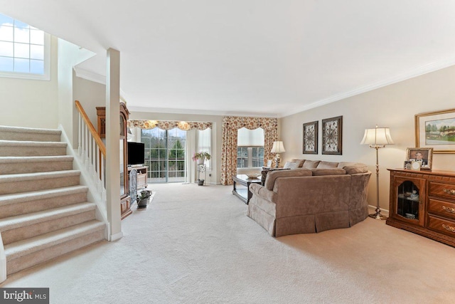 living area with carpet flooring, crown molding, and stairway