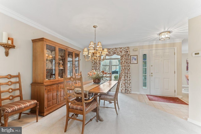 dining room with a chandelier, light carpet, and ornamental molding