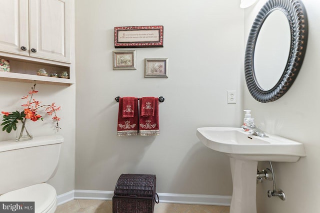 bathroom featuring toilet, tile patterned flooring, and baseboards