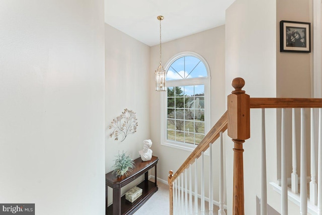 staircase with baseboards and a notable chandelier