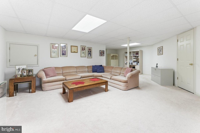 carpeted living room featuring a drop ceiling