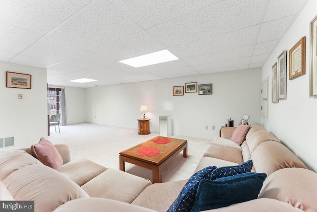 carpeted living room featuring baseboards, visible vents, and a drop ceiling