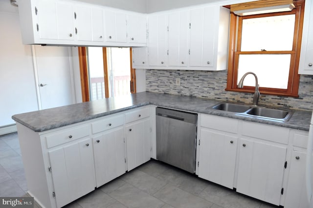 kitchen with a sink, backsplash, a peninsula, and stainless steel dishwasher