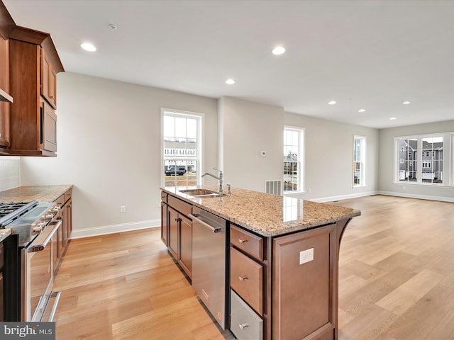 kitchen with appliances with stainless steel finishes, recessed lighting, a sink, and light wood-style floors