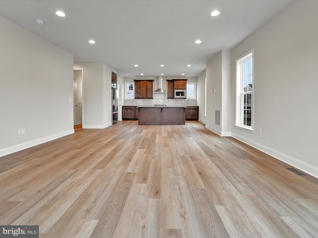 unfurnished living room featuring recessed lighting, visible vents, light wood-style flooring, and baseboards