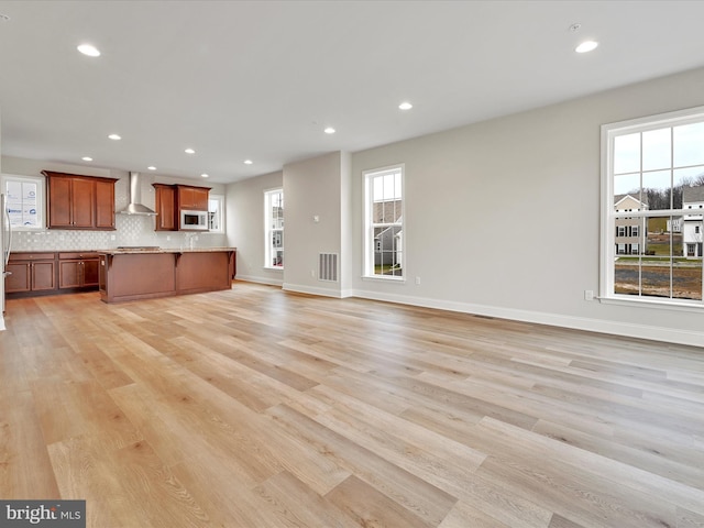 unfurnished living room featuring baseboards, light wood-type flooring, visible vents, and recessed lighting