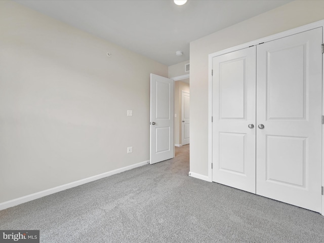 unfurnished bedroom featuring carpet, baseboards, and a closet