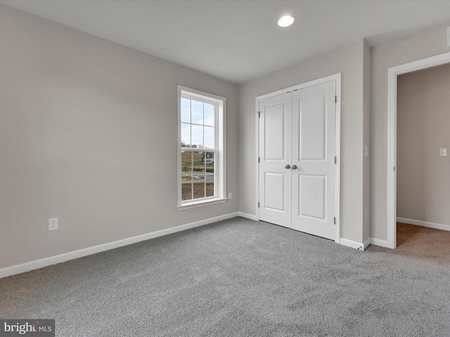 unfurnished bedroom featuring carpet floors, a closet, and baseboards