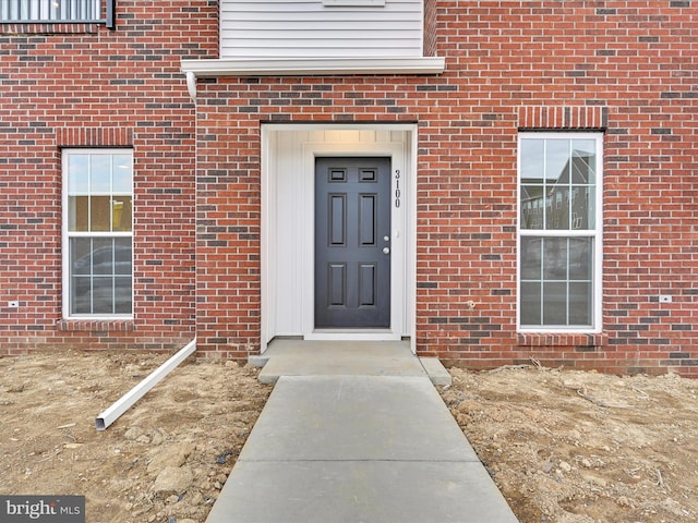 doorway to property with brick siding