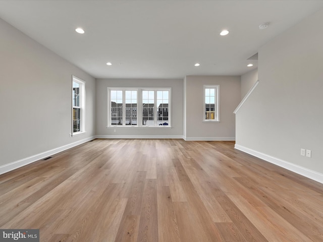 unfurnished living room with recessed lighting, visible vents, light wood-style flooring, and baseboards