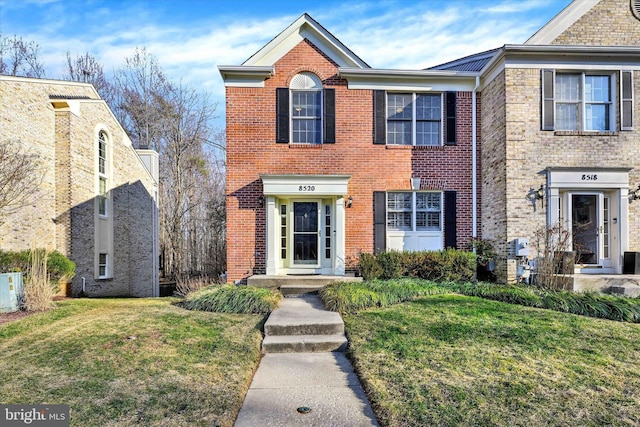 view of front of house with brick siding and a front lawn