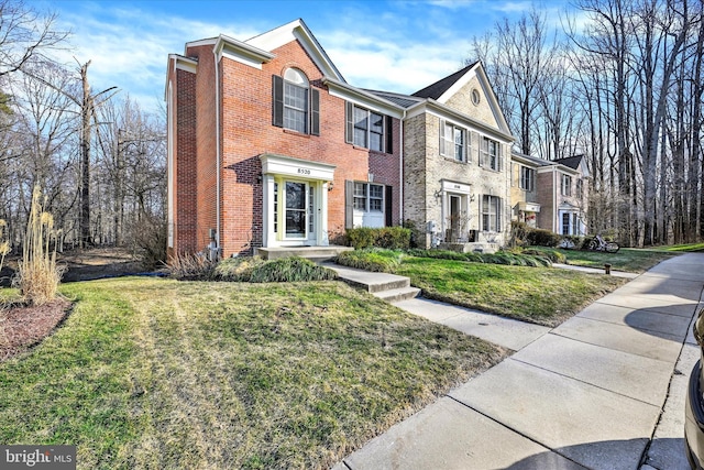 view of front of property with brick siding and a front lawn