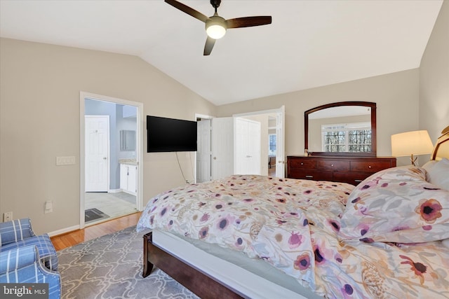 bedroom featuring connected bathroom, wood finished floors, a ceiling fan, baseboards, and vaulted ceiling