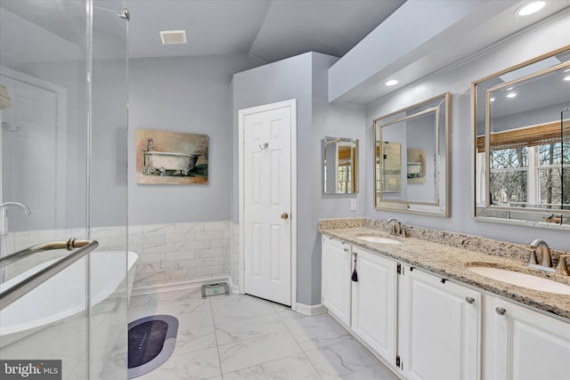 full bath with double vanity, marble finish floor, visible vents, and a sink