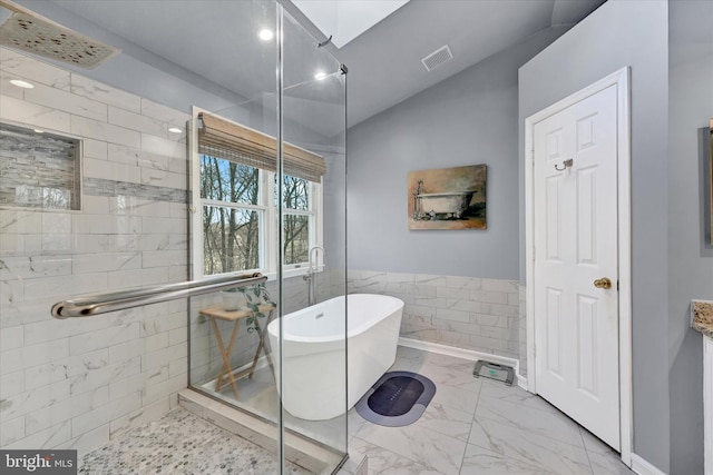 full bath featuring marble finish floor, tile walls, a soaking tub, visible vents, and a shower stall